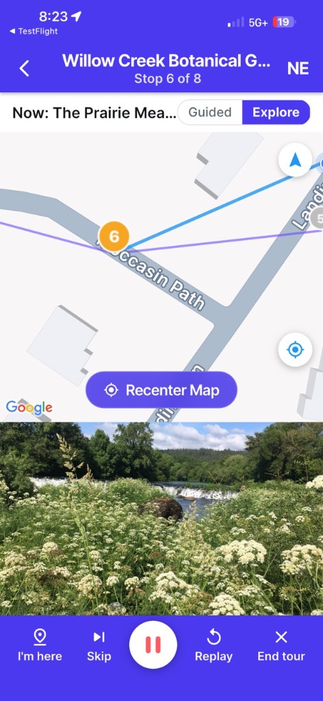 A tour stop in the USTourGuide app: Willow Creek Botanical Garden, stop 6 of 8, with the stop photo and playback controls
